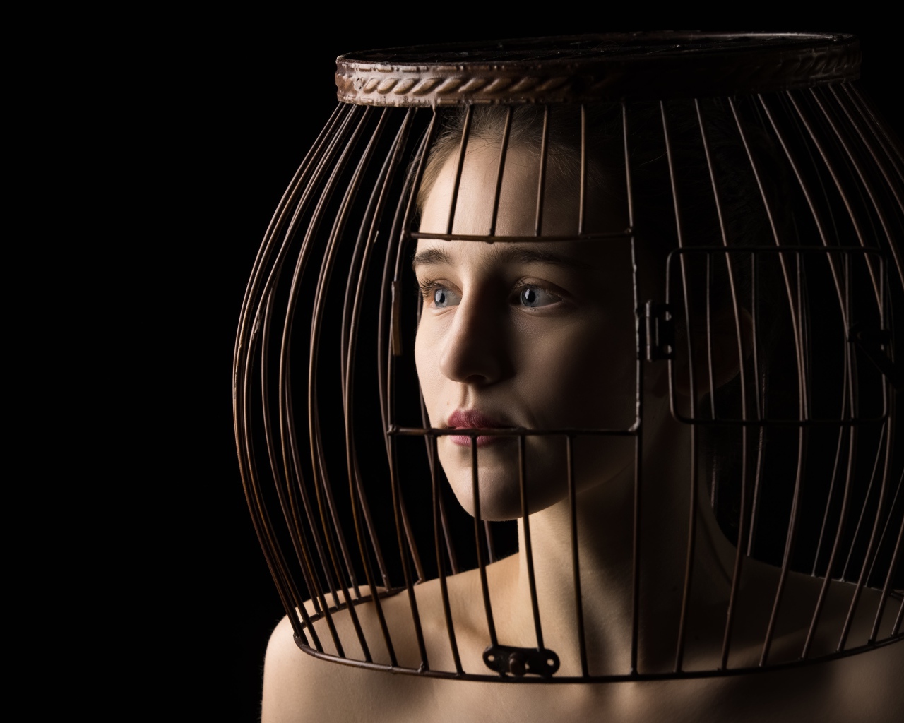 Молодая девушка с клеткой на голове 