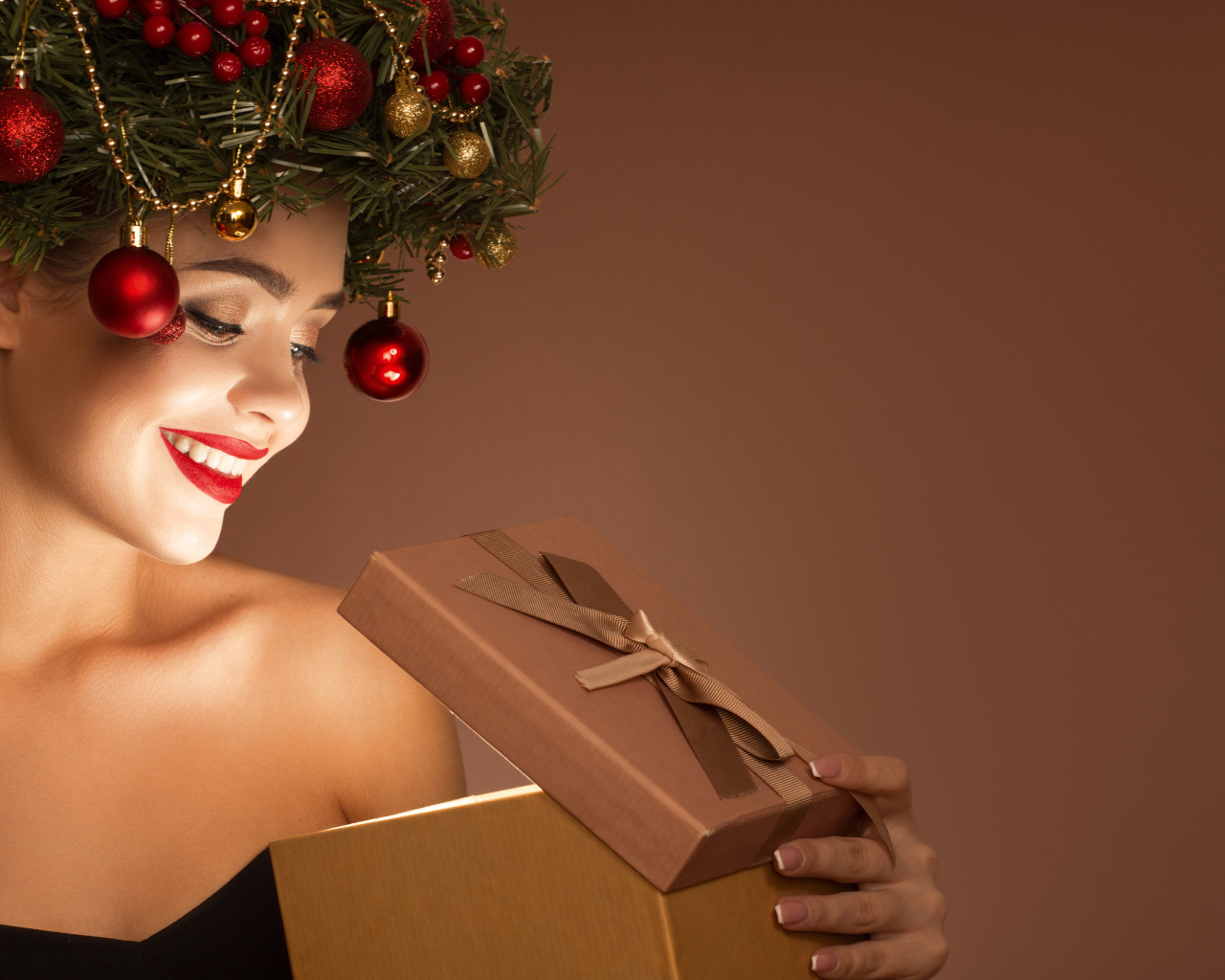 Красивая девушка с рождественским венком на голове с подарком