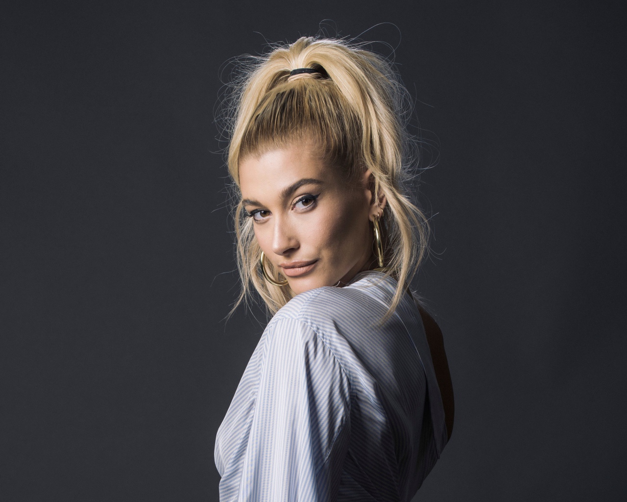 Красивая блондинка, американская модель Хейли Болдуин на сером фоне