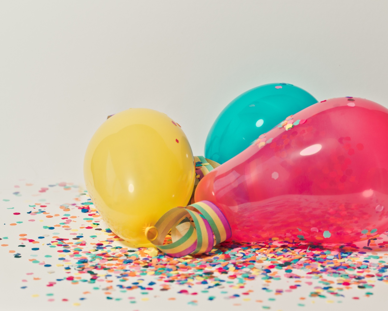 Balloons with confetti on gray background