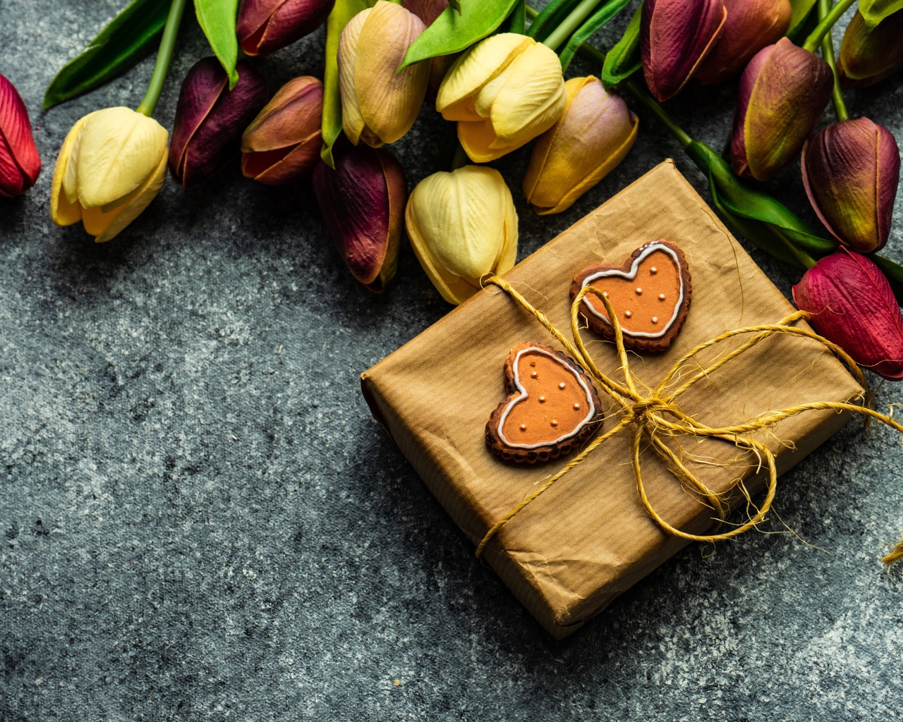 Подарок с букетом тюльпанов на сером столе