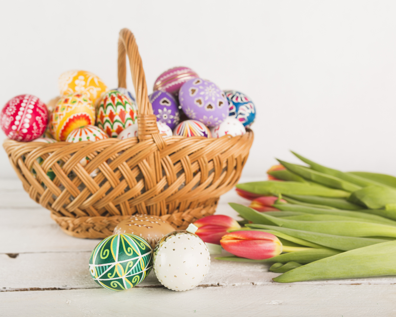 Корзинка с разноцветными яйцами и тюльпанами на Светлый праздник Пасха