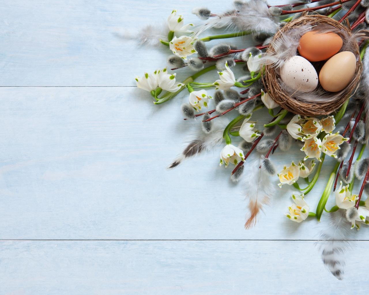 Eggs in a nest on a table with willow branches for Easter