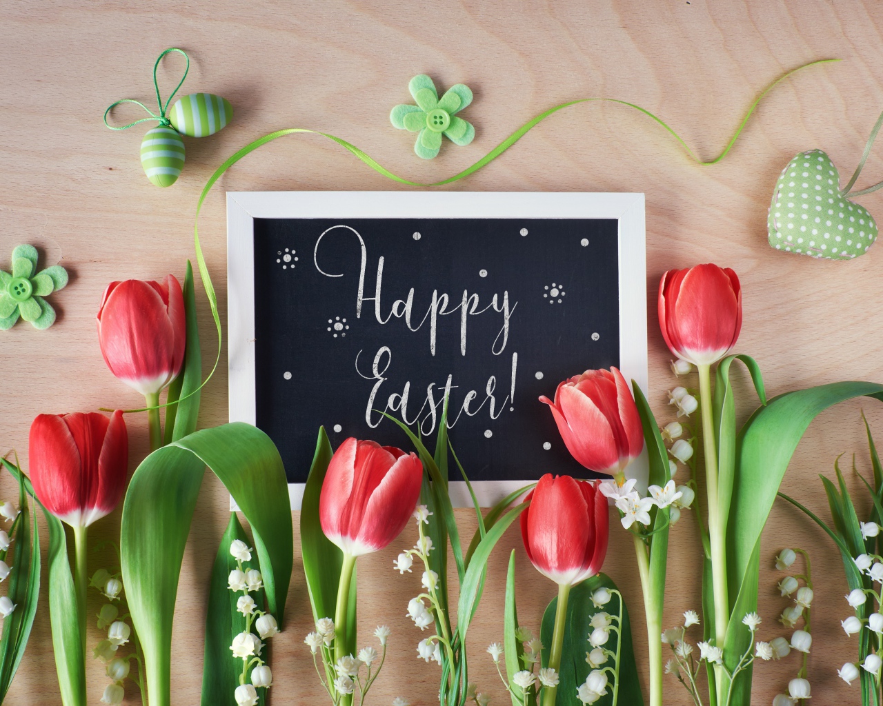 Надпись Счастливой Пасхи на столе с букетом тюльпанов