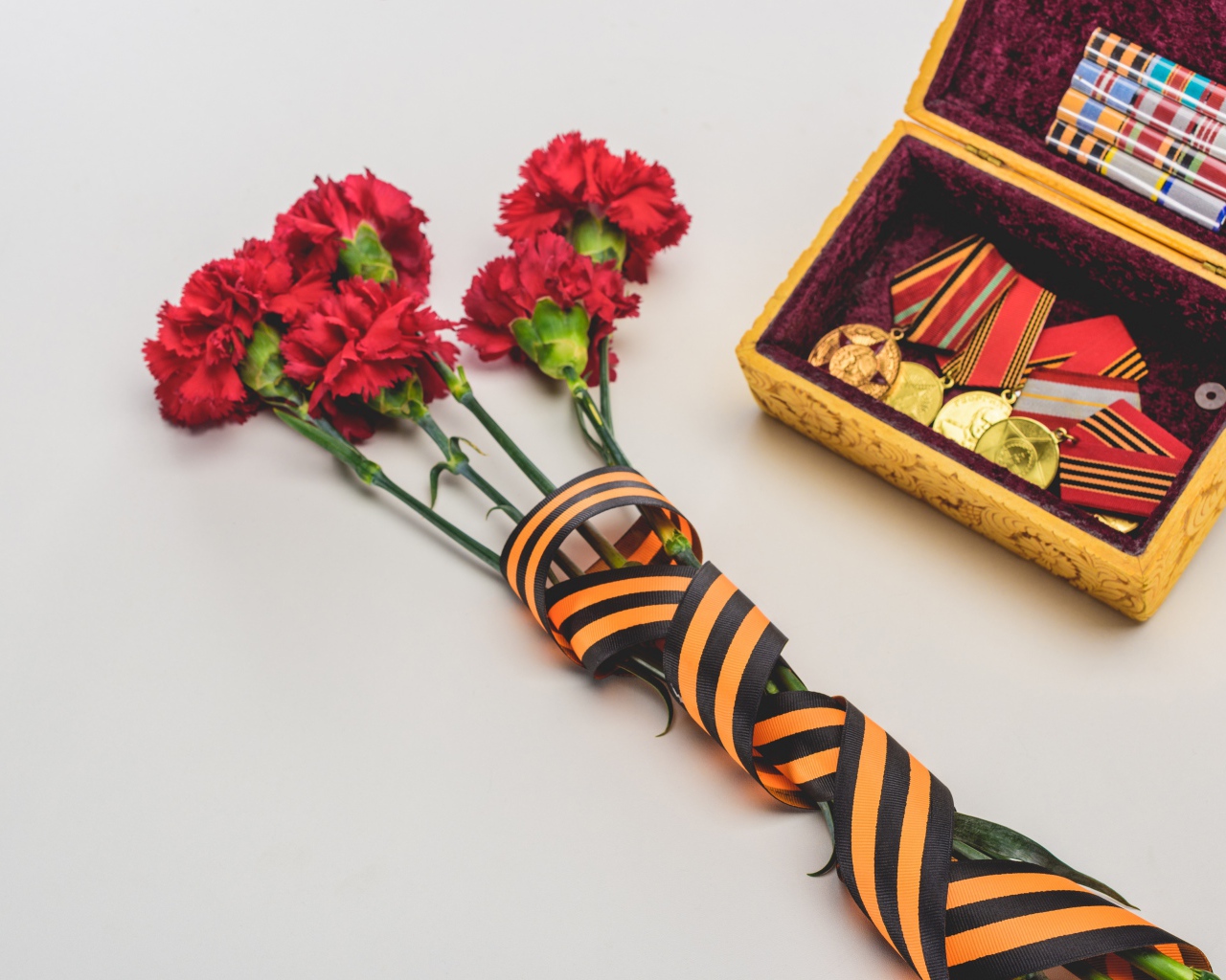 Букет гвоздик с георгиевской лентой и наградами на День Победы 9 мая