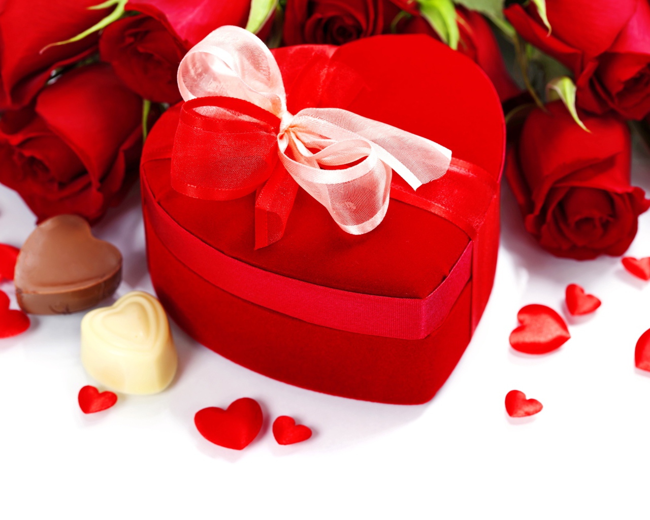 Красная коробка в форме сердца на столе с розами и конфетами для любимой