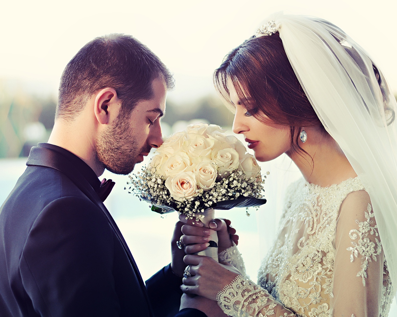 Жених и невеста с букетом белых роз 