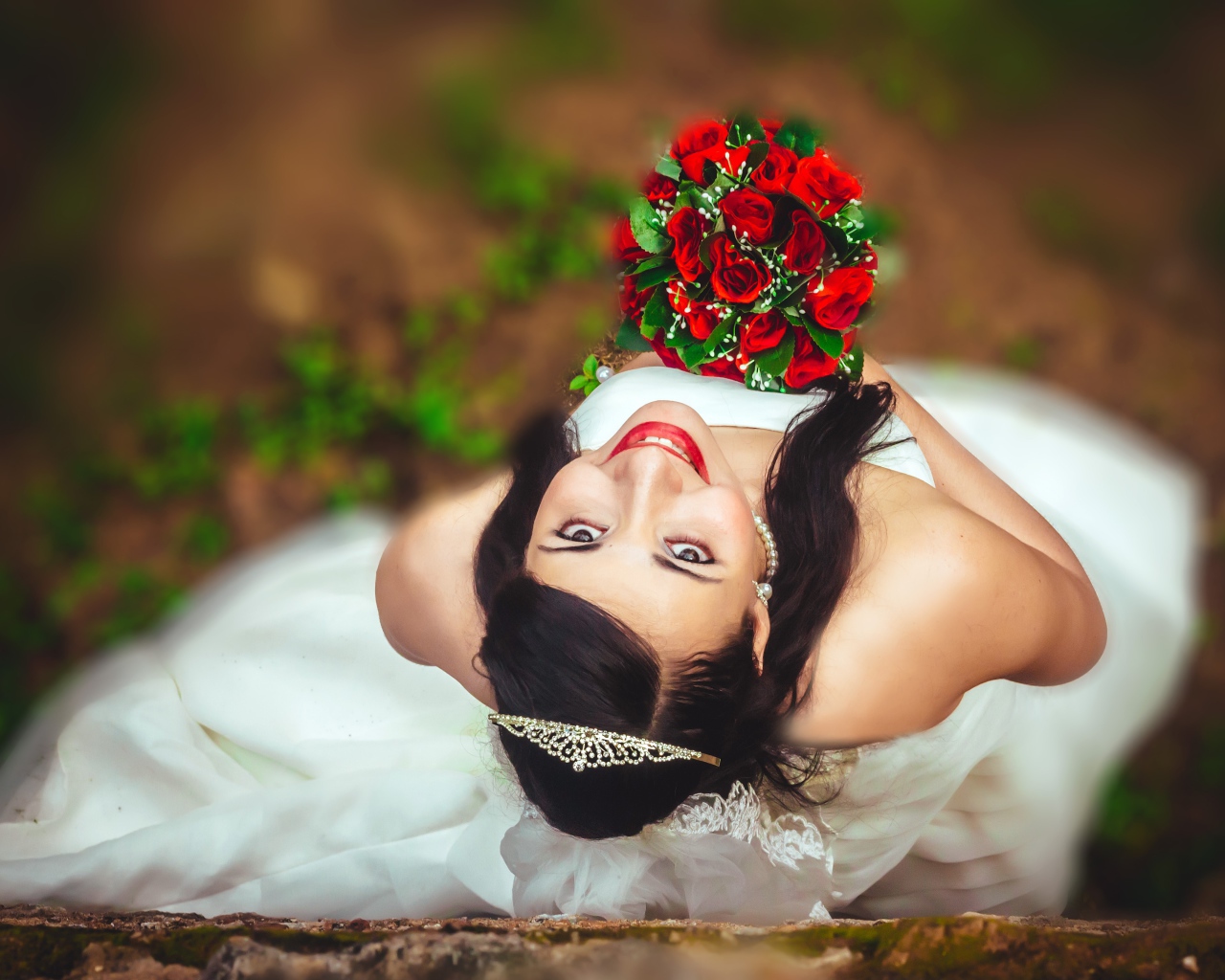 Улыбающаяся девушка невеста с букетом красных роз