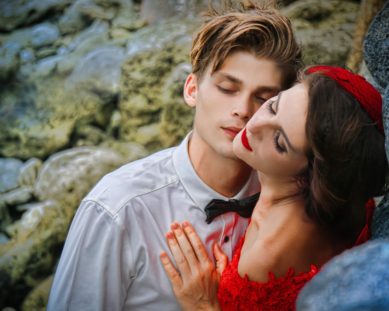 Красивая влюбленная пара стоит у камней