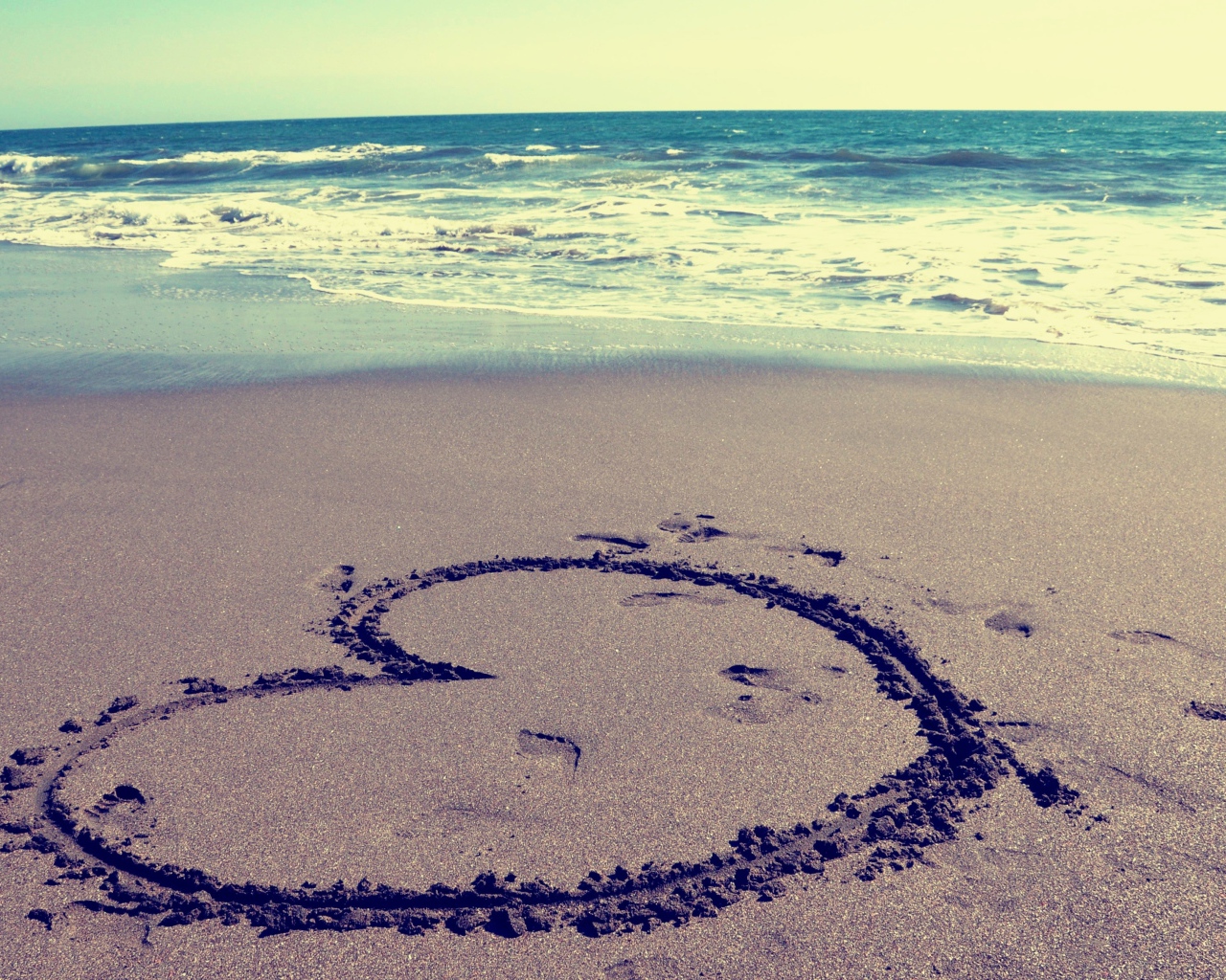 Большое сердце на мокром песке на пляже