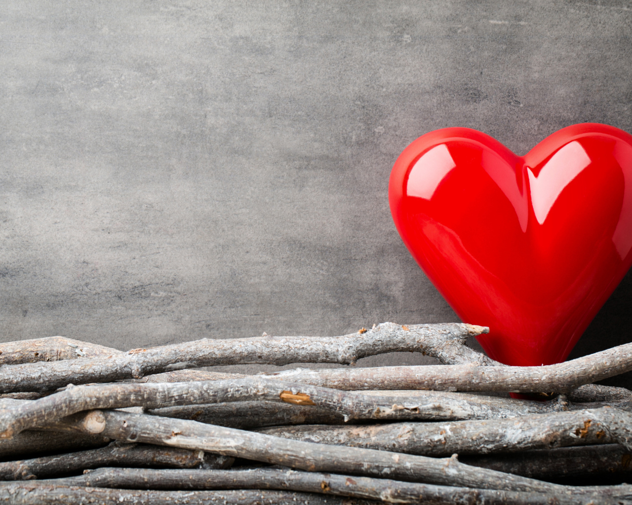 Большое красное сердце на сером фоне с деревянными прутьями
