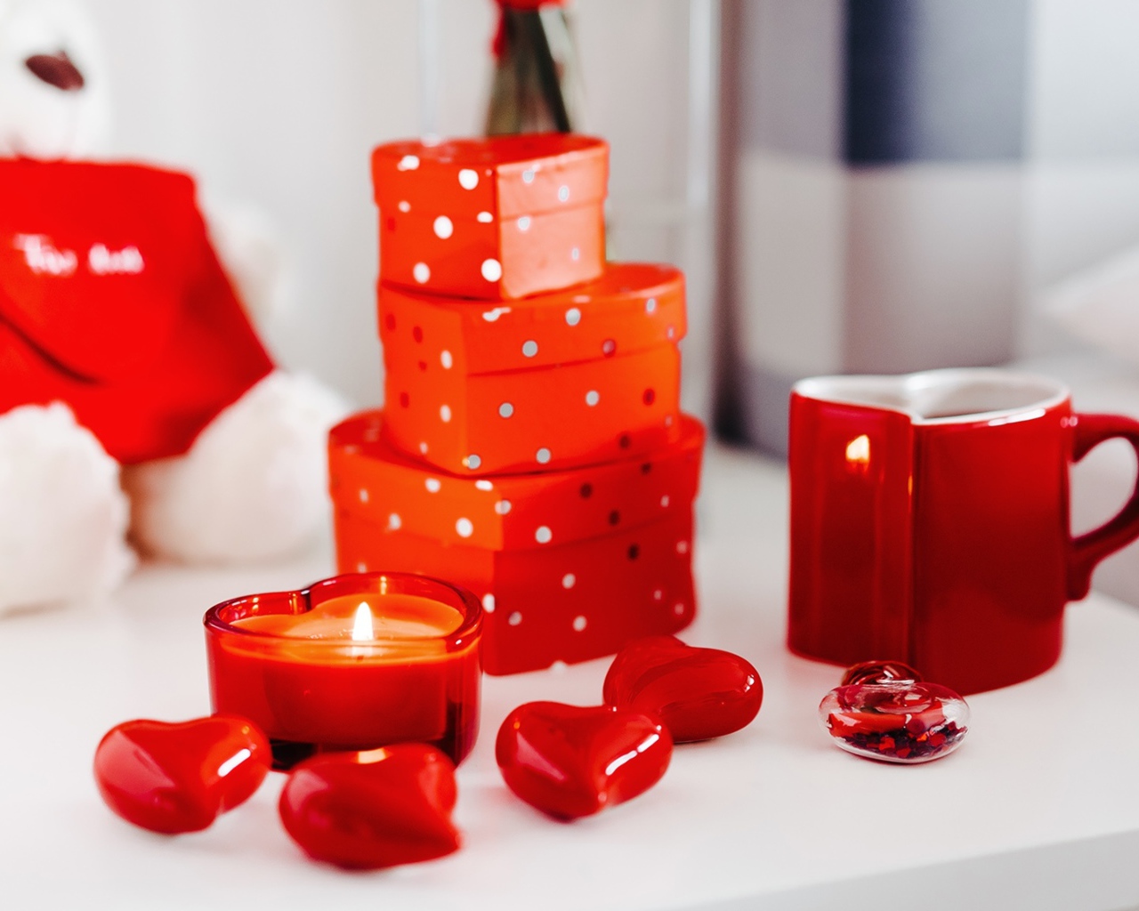 Чашка кофе на столе с подарками, зажженными свечами и сердечками