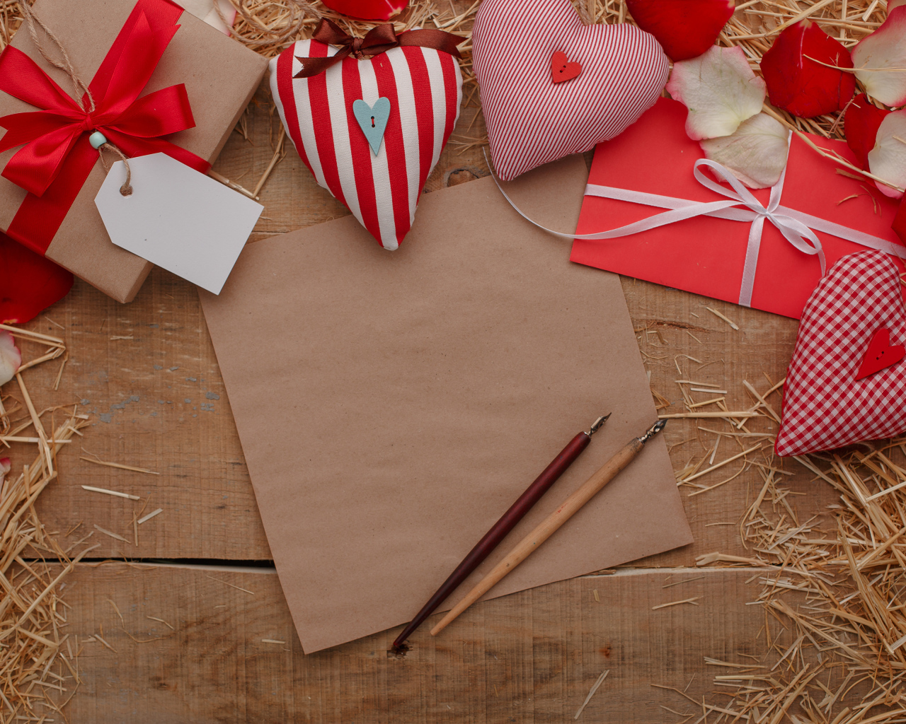 Сердечки из ткани на столе с бумагой и подарками 