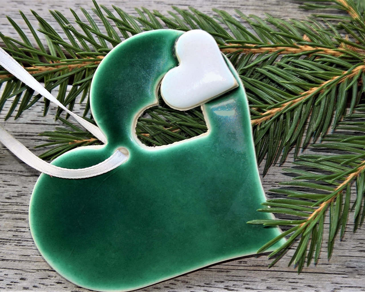 Зеленое сердце с еловой веткой на столе 