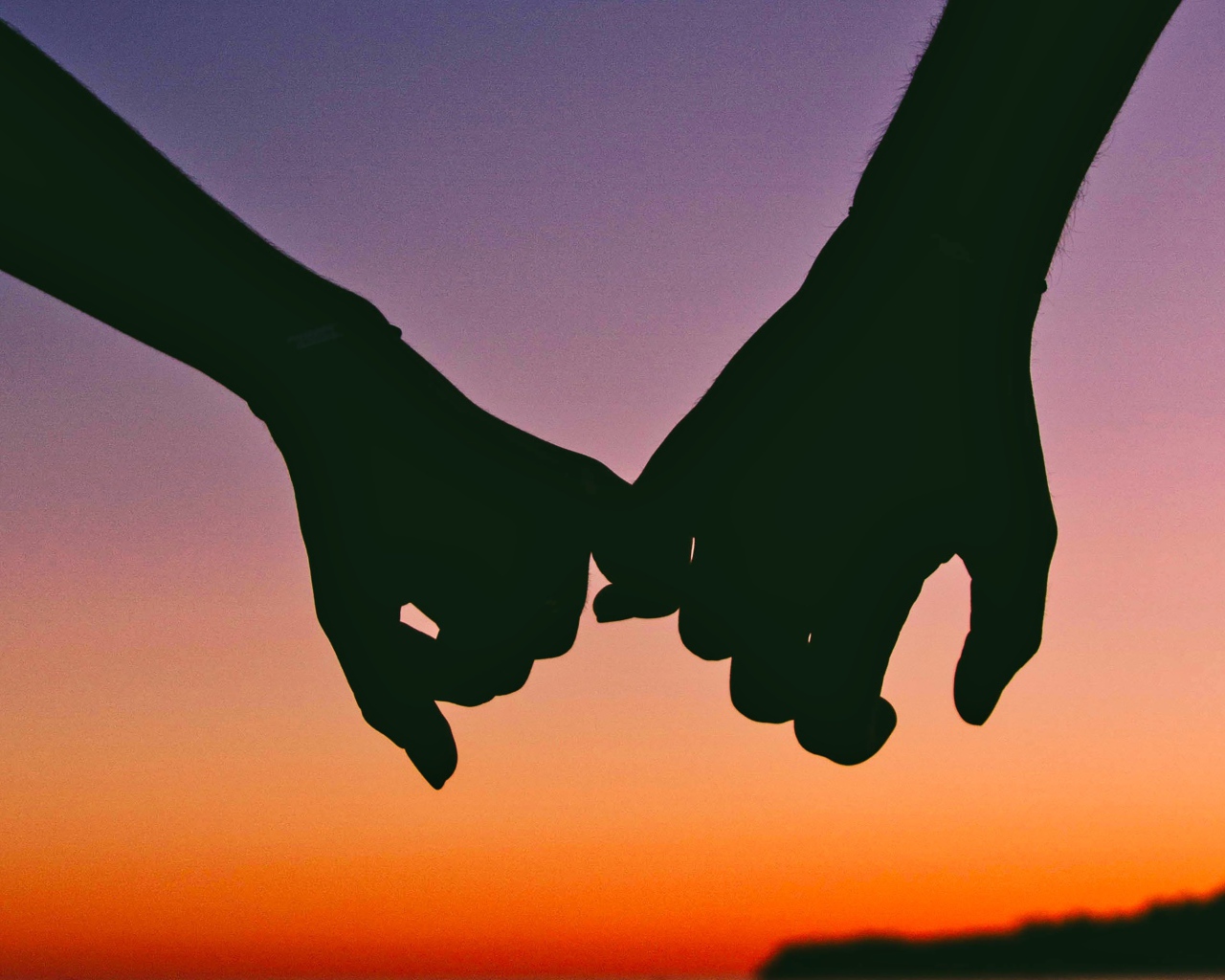 Руки влюбленной пары на закате солнца 