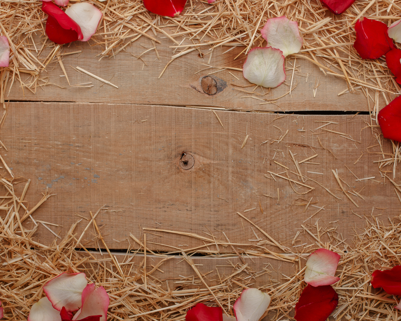 Сено и лепестки роз на деревянном столе 