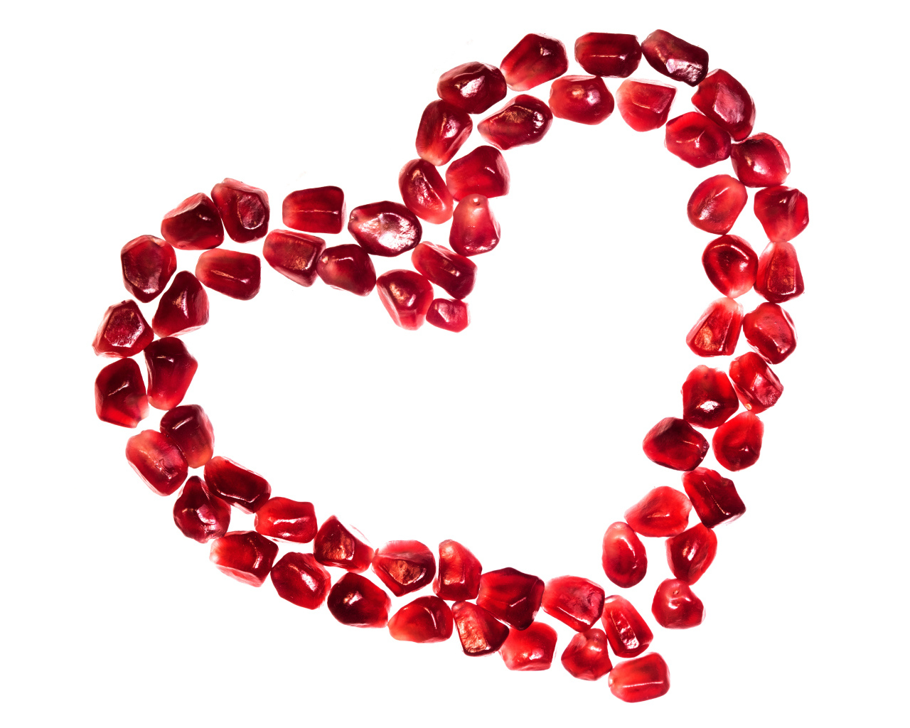 Сердце из гранатовых зерен на белом фоне