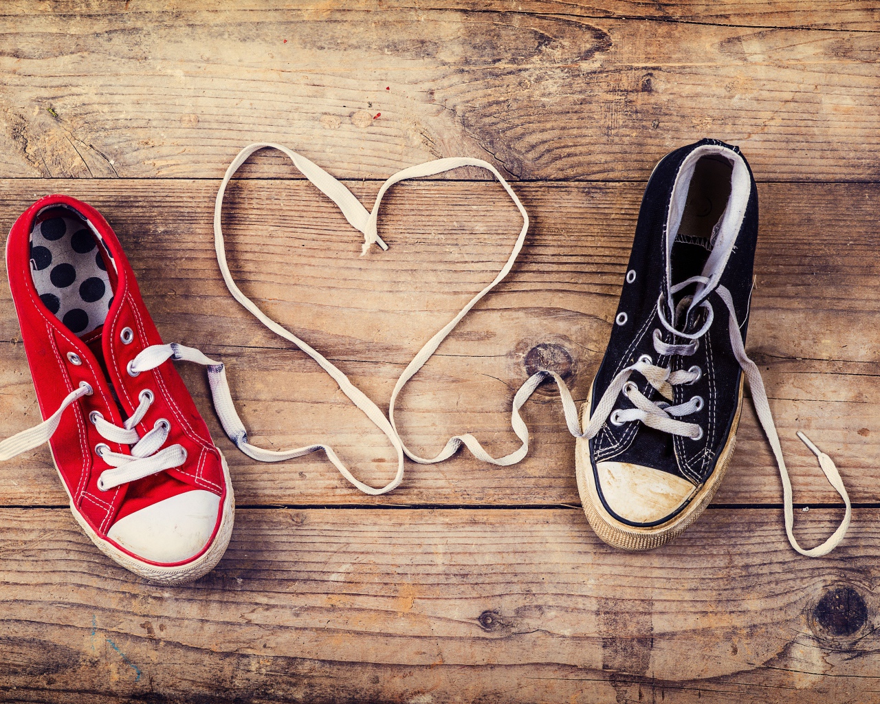 Сердце из шнурков кед на деревянном столе 