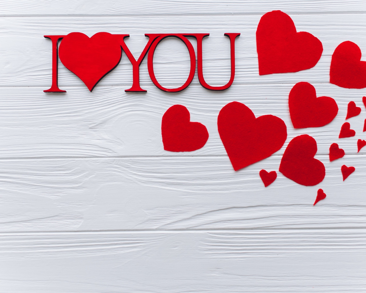 Надпись Я тебя люблю с красными сердечками на столе