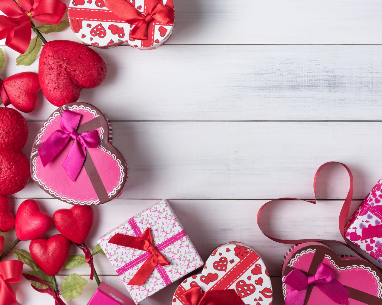 Много подарочных коробок в форме сердца на сером столе 