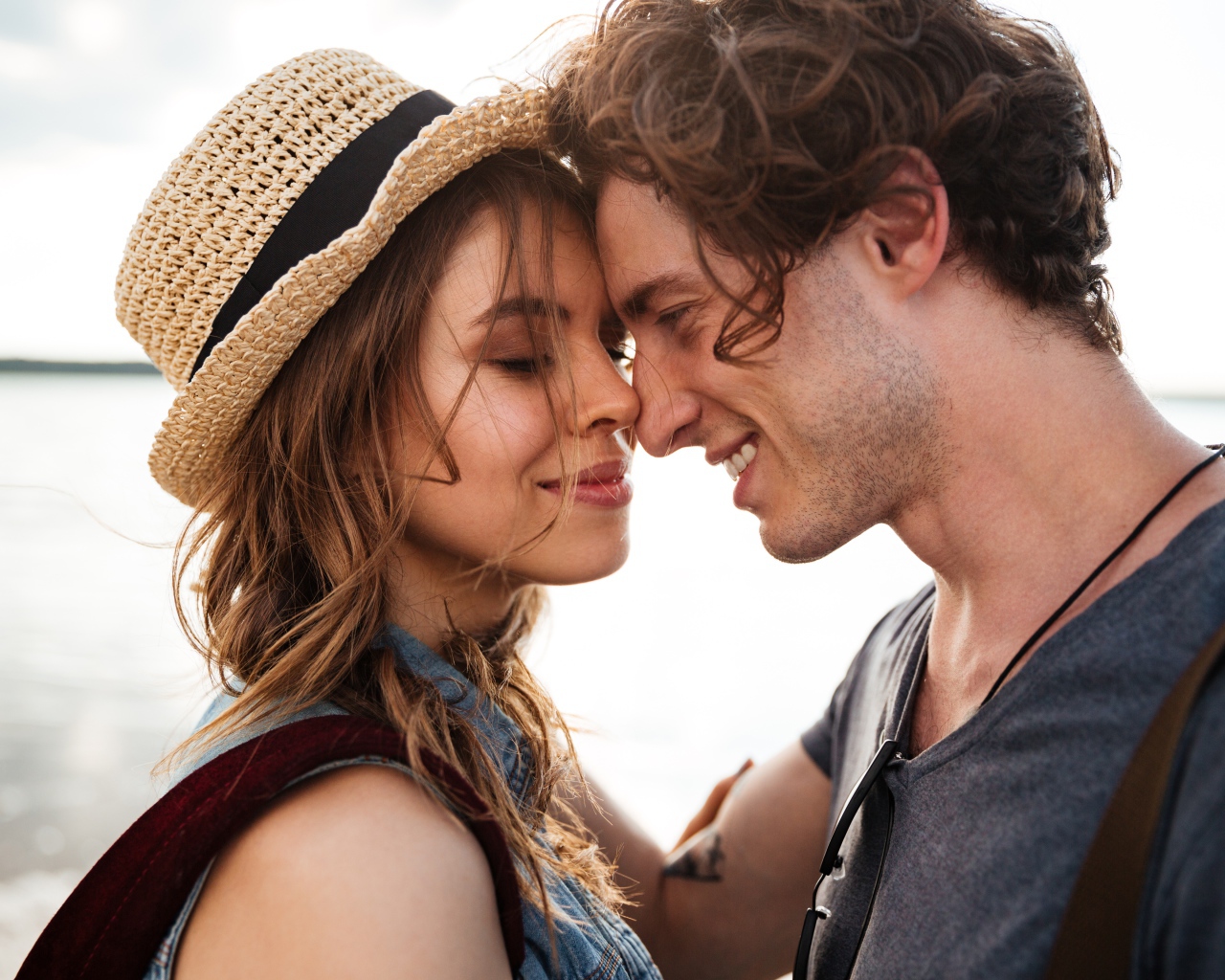 Влюбленная пара стоит на фоне моря 