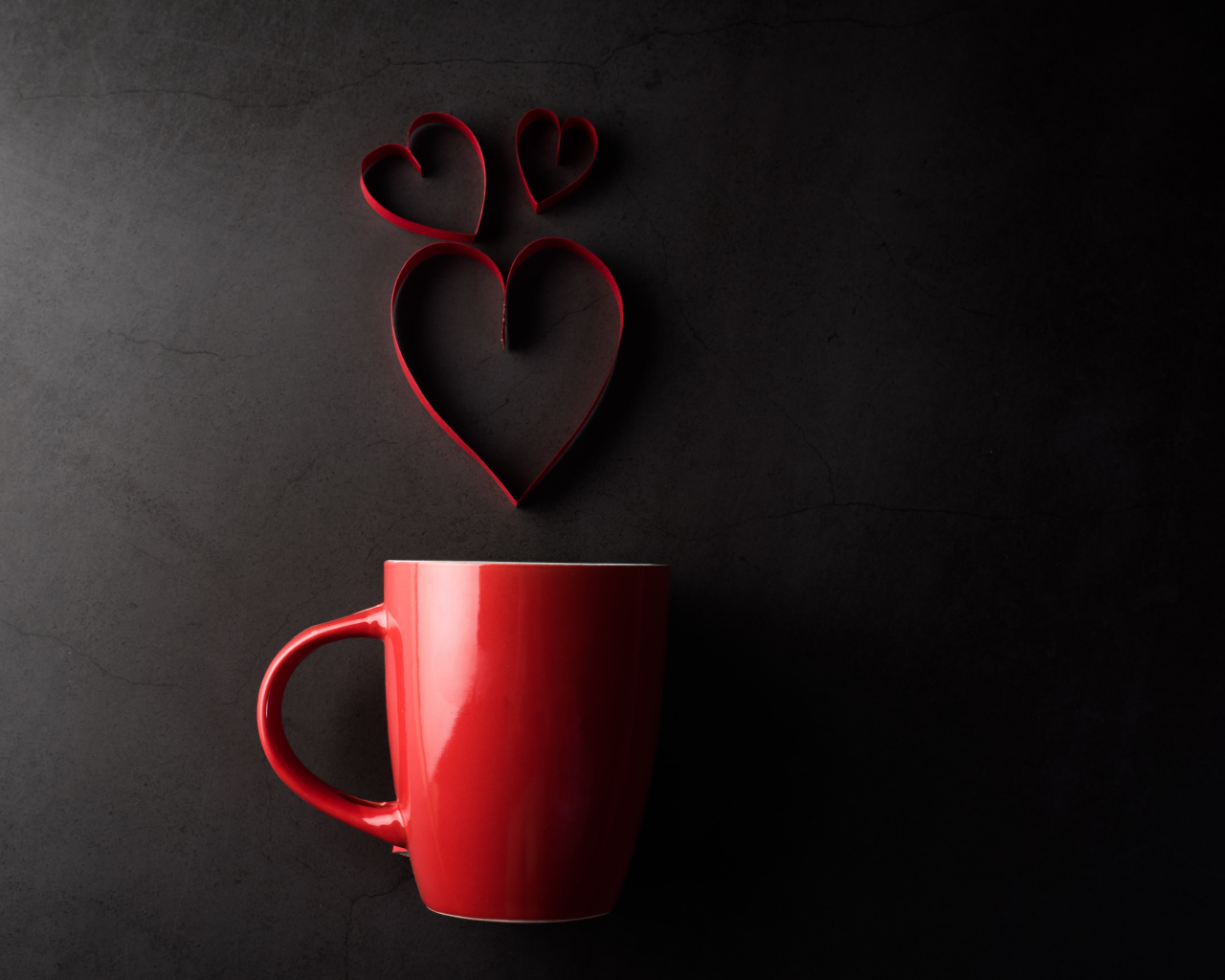 Красная чашка на сером фоне с сердечками