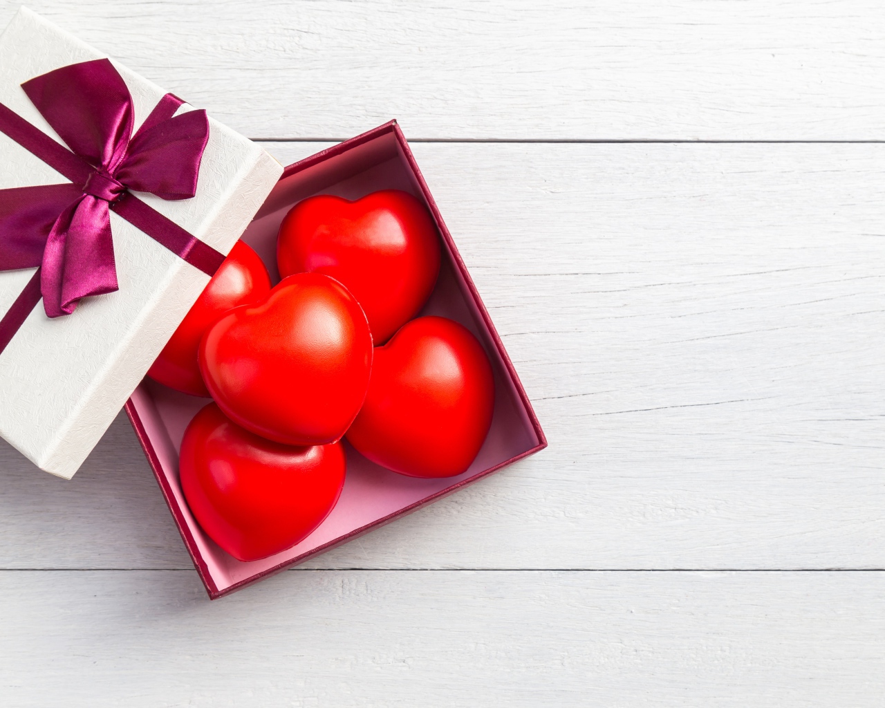 Красные сердечки в коробке на сером фоне