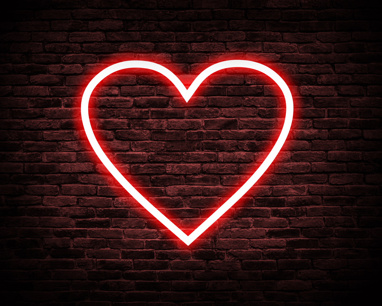 Красное неоновое сердце на кирпичной стене 