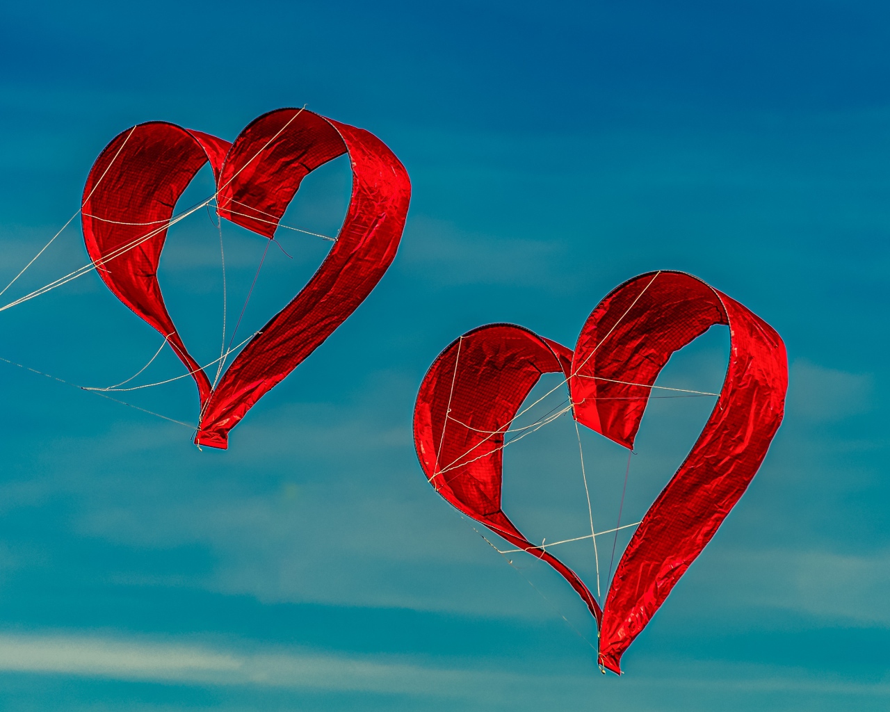 Два воздушных змея в форме сердца в небе