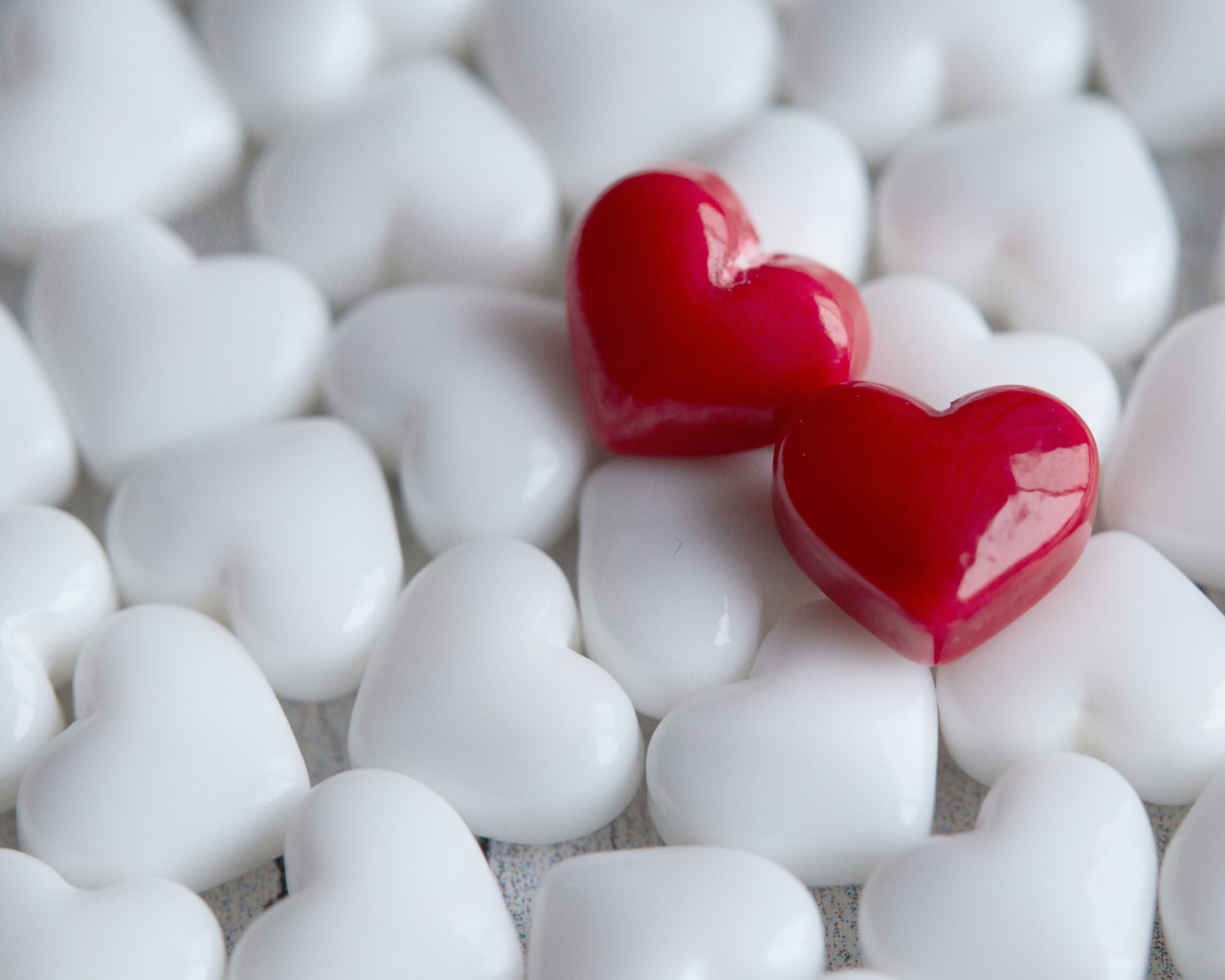 Два красных сердца лежат на белых 