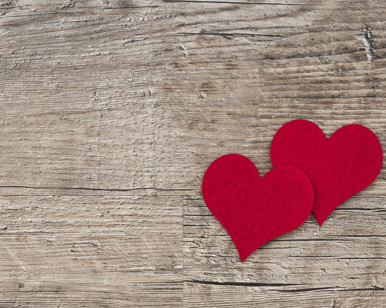 Два красных сердца на деревянном столе