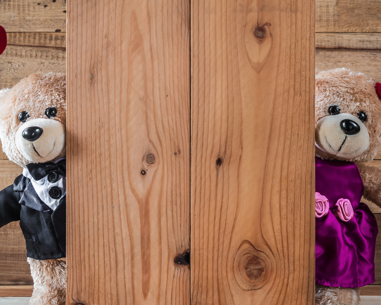 Два плюшевых медведя с сердечками у стены