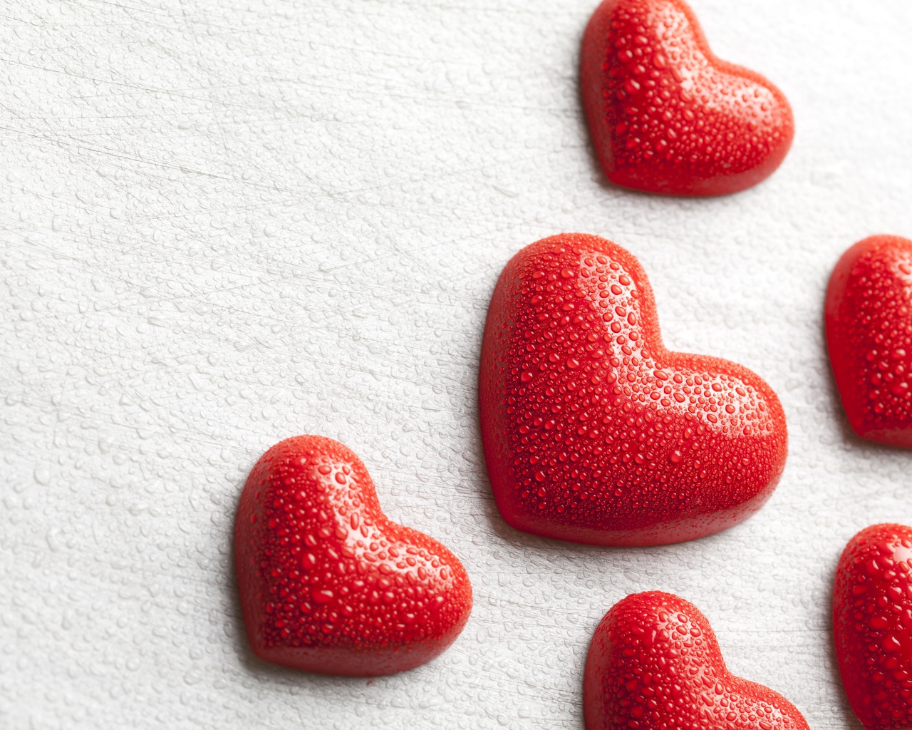 Мокрые красные сердечки на белом фоне