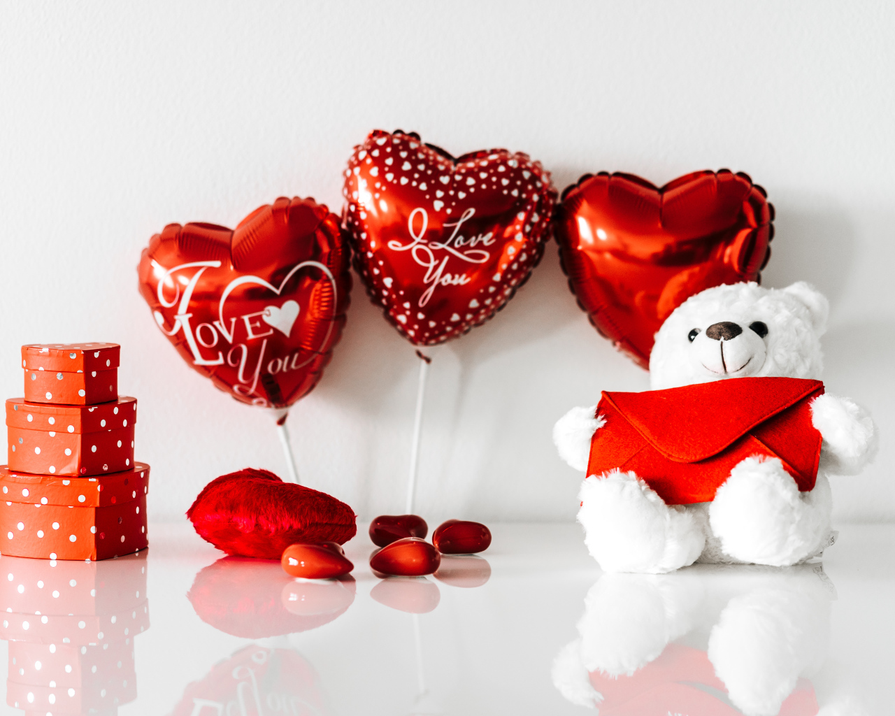 Белый мишка с подарками и шариками у стены