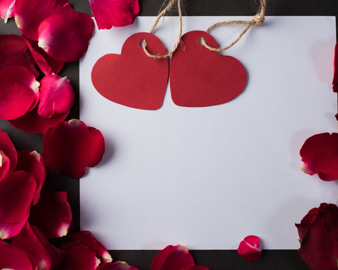 Белый лист бумаги с сердечками и лепестками роз 