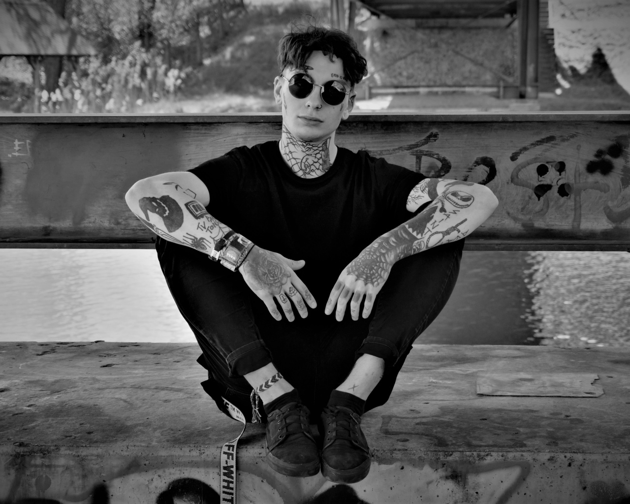 A man in black glasses with tattoos on his body.