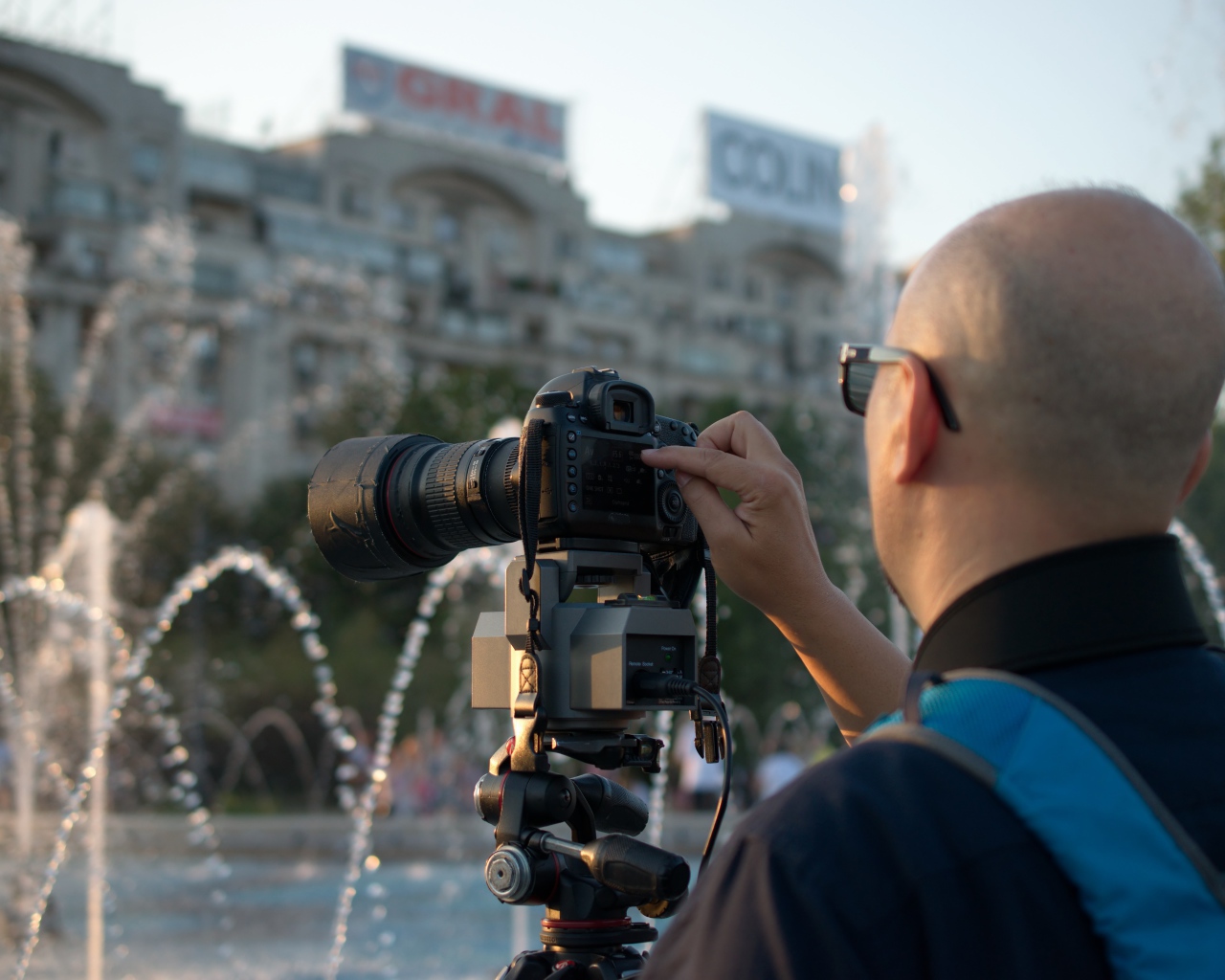 Мужчина снимает на камеру фонтан в парке