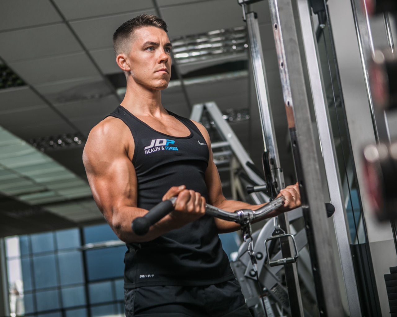 Накаченный мужчина занимается на тренажере в спортзале