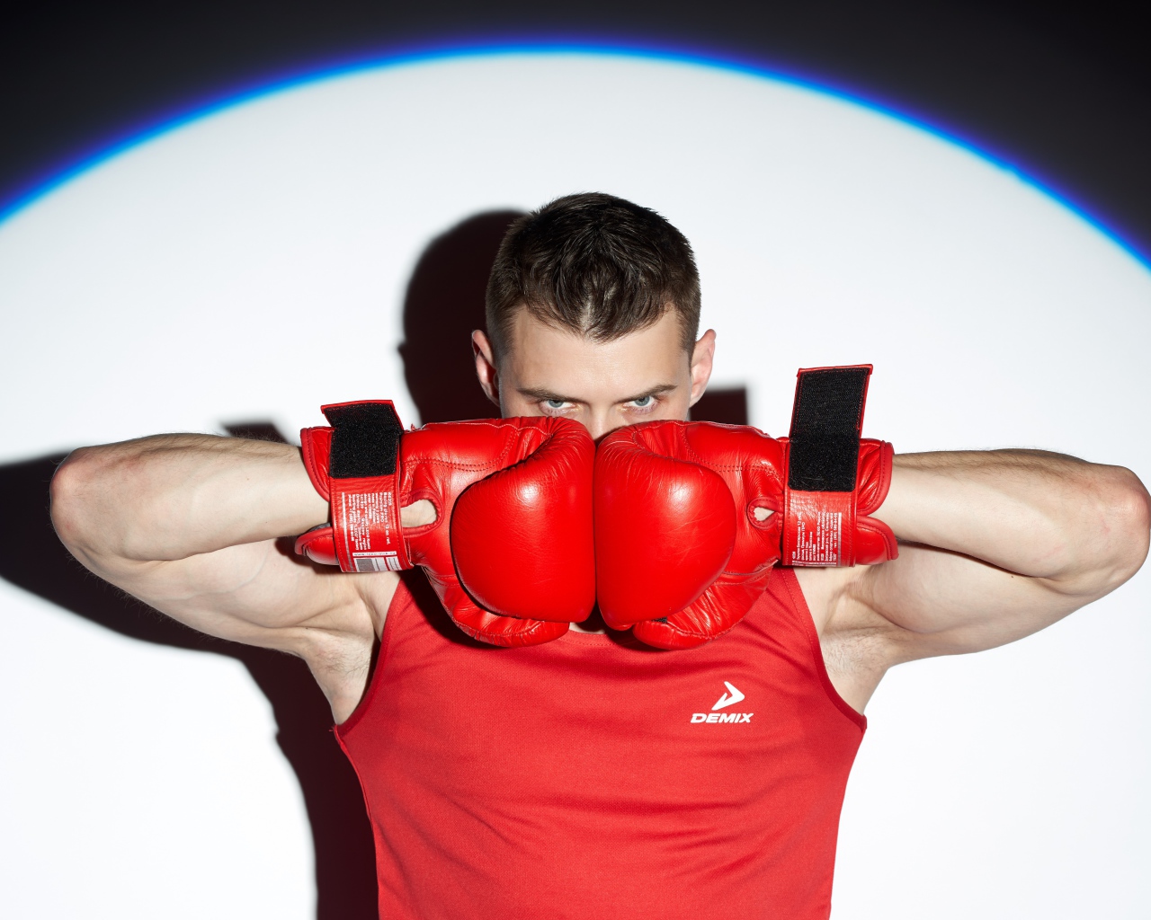 Мужчина боксер с красных перчатках в свете прожектора 