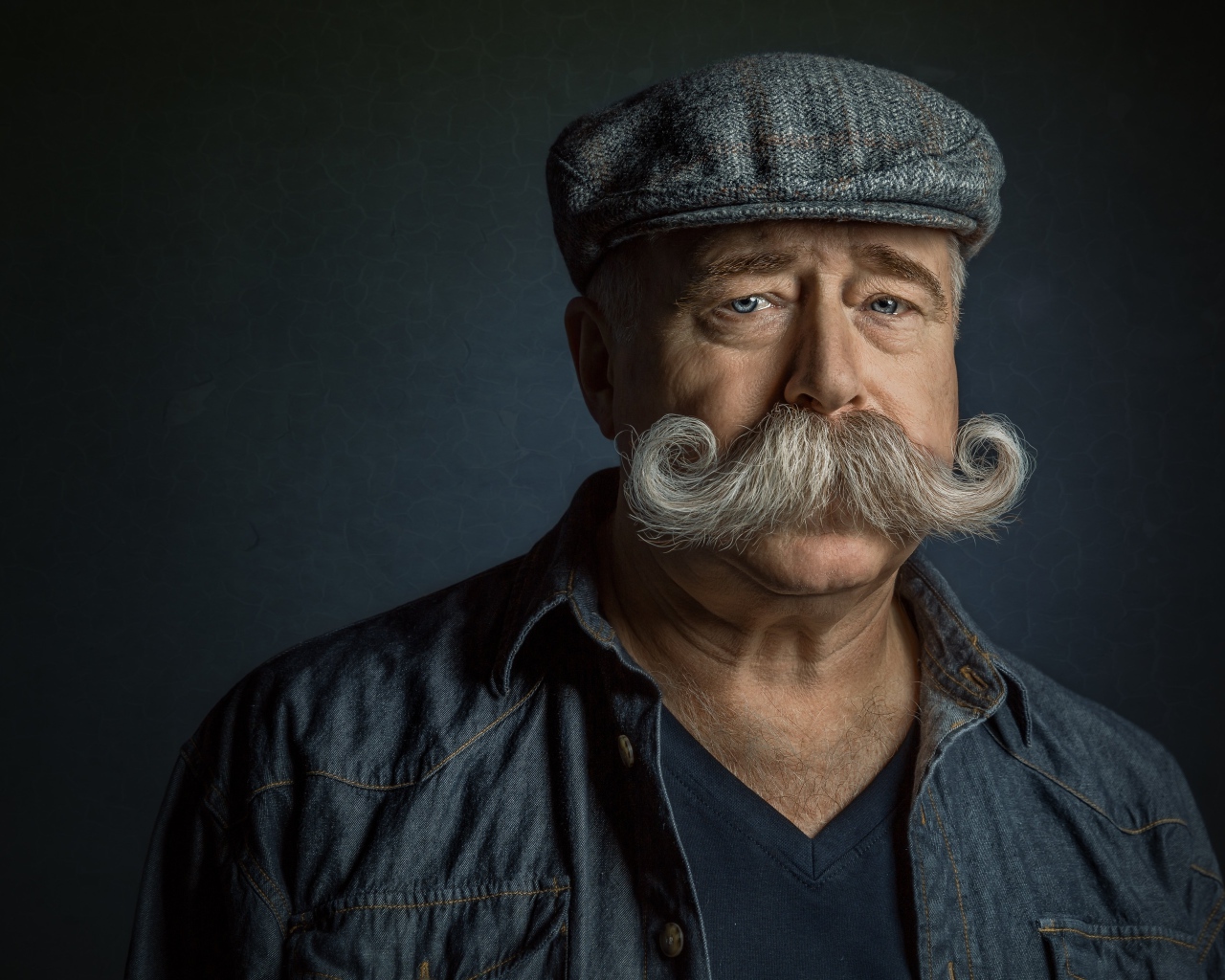 Мужчина в кепке с большими усами на лице 