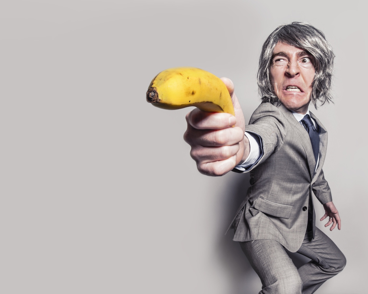 Мужчина в костюме защищается бананом