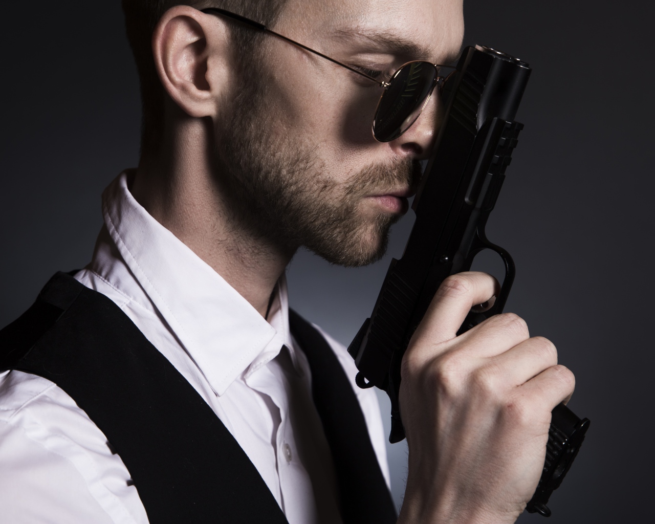 Мужчина в очках с пистолетом в руке