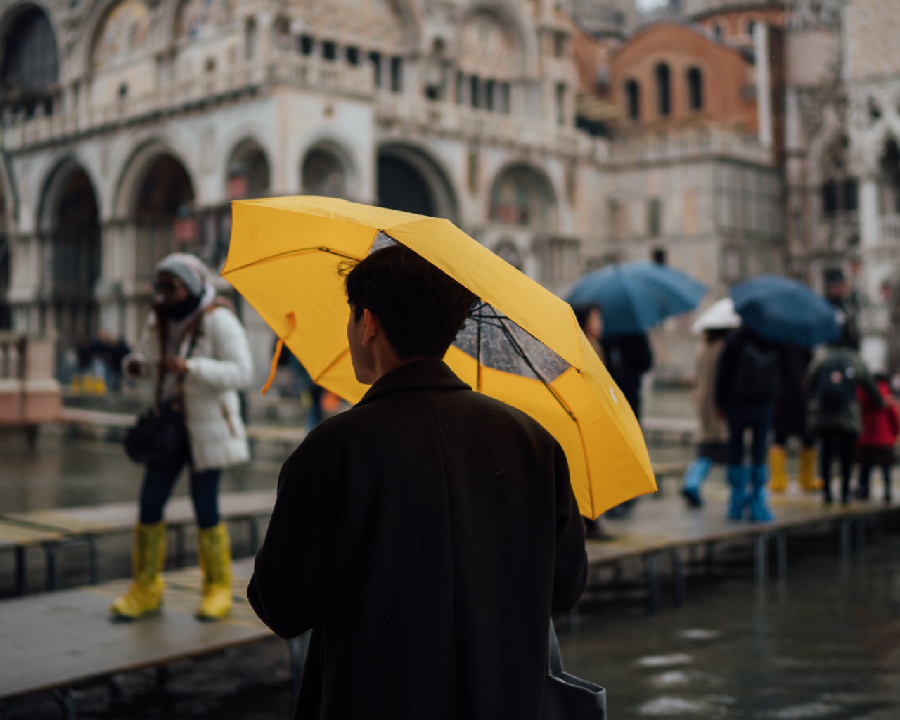 Мужчина с желтым зонтом в городе 