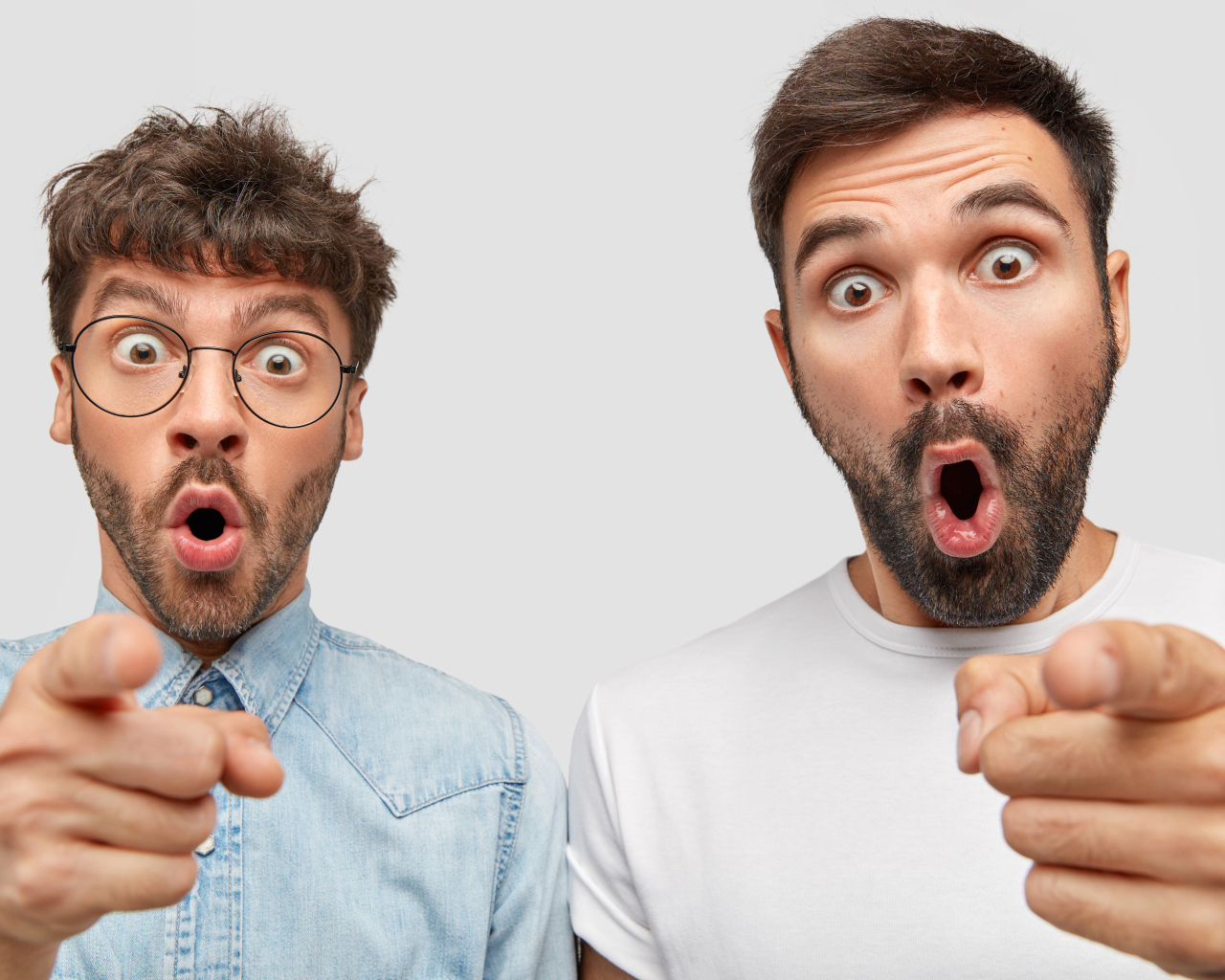 Два удивленных мужчины на сером фоне