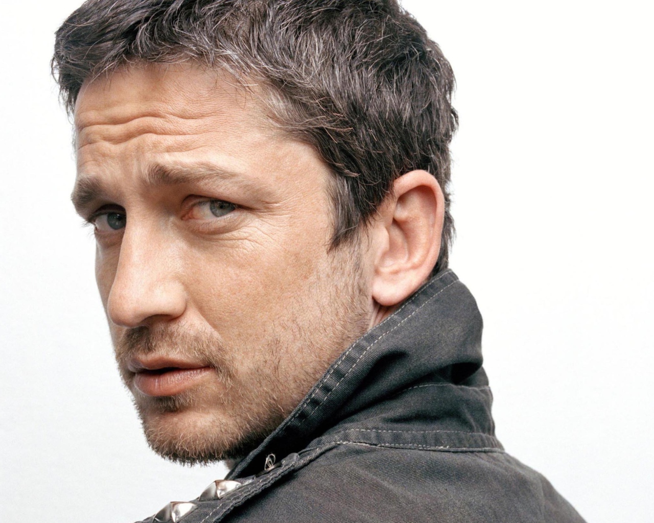 Актер Джерард Батлер крупным планом на белом фоне