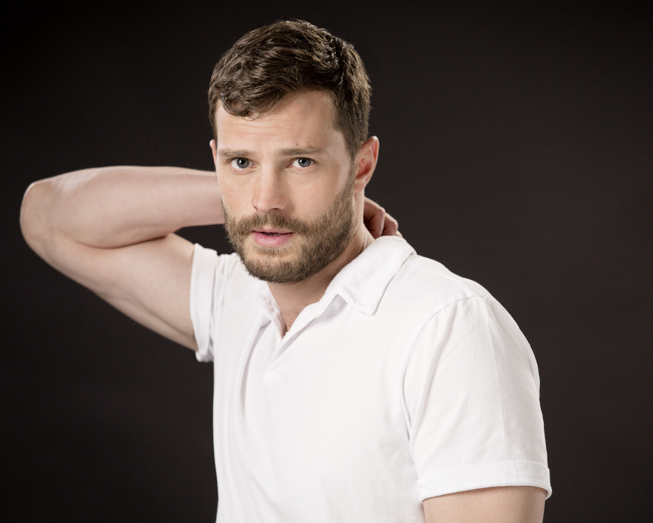 Актер Джейми Дорнан в белой рубашке на коричневом фоне