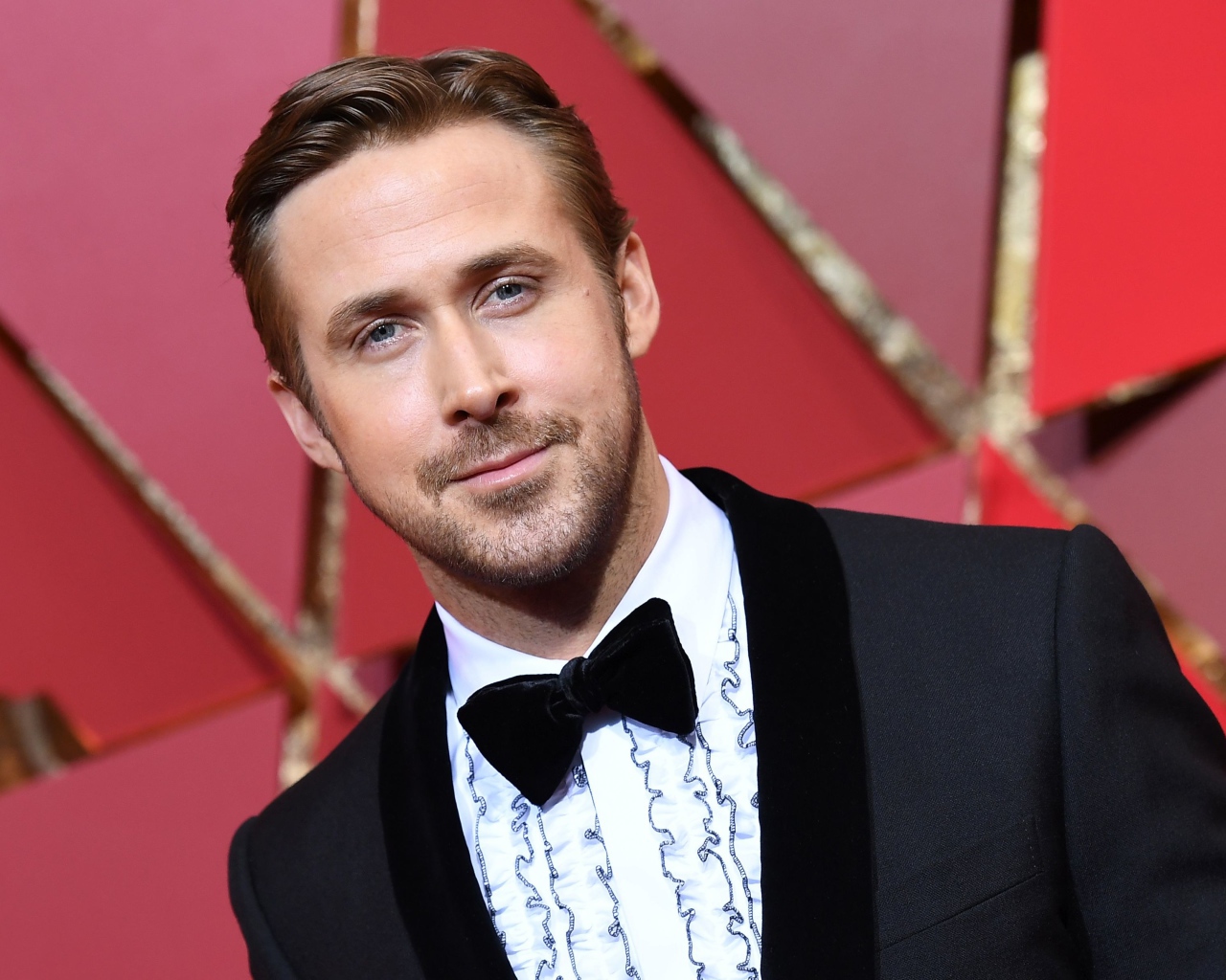 Актер Райан Гослинг в костюме на красном фоне