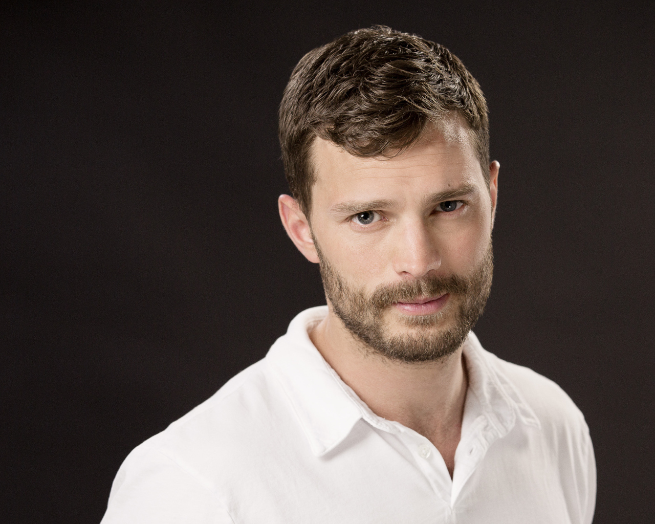 Красивый мужчина, актер Джеми Дорнан в белой рубашке