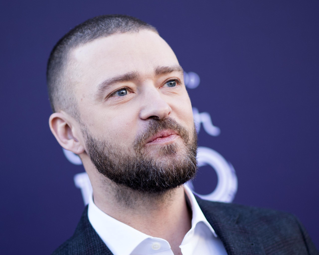 Лицо голубоглазого актера Джастина Тимберлейка на синем фоне