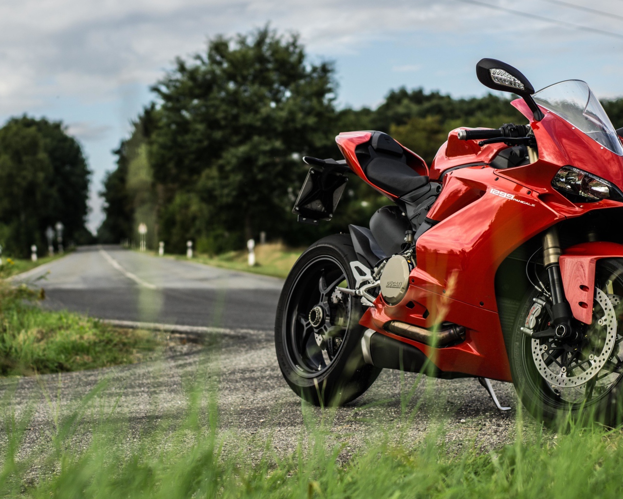 Красны мотоцикл Ducati 1299 Panigale на трассе 
